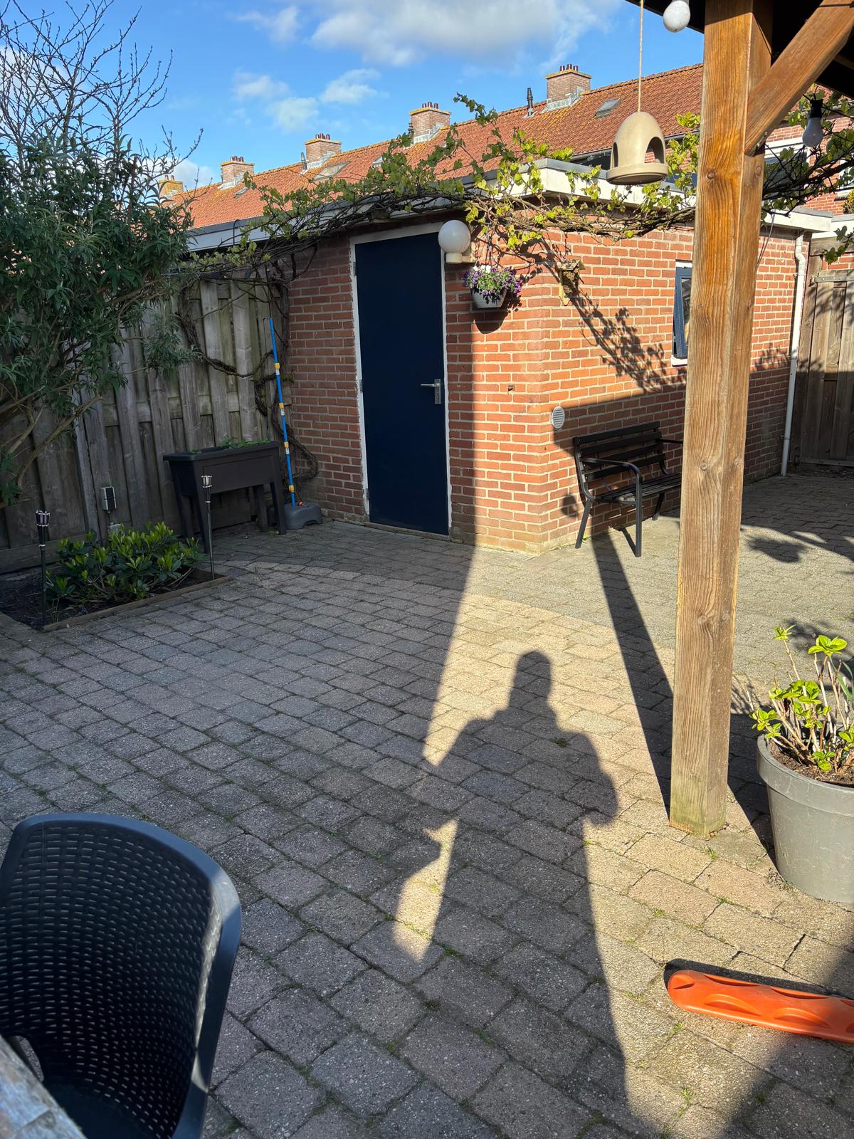 Bestrating en zithoek met hangstoel onder pergola